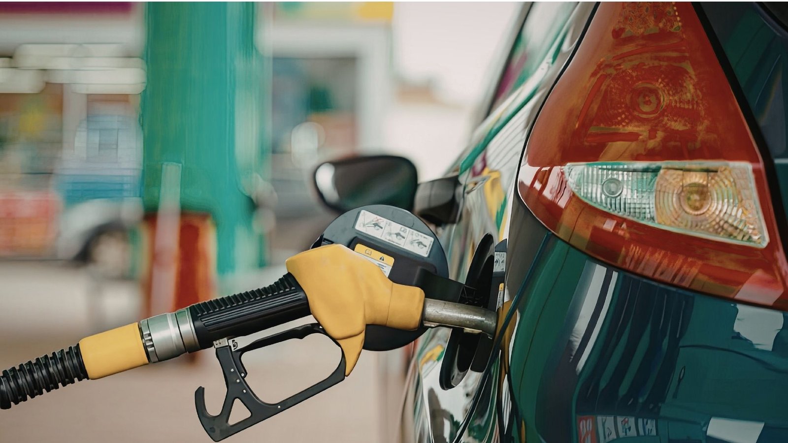 Bico de abastecimento amarelo no tanque de um carro em um posto de combustível
